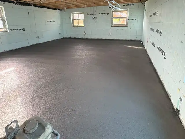A sand and cement screed floor in a room with insulated walls